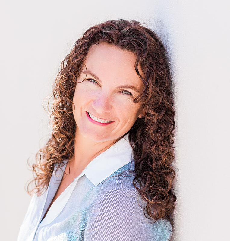 Headshot of Shannon Landin from the shoulders up, smiling and wearing a light blue collared shirt.